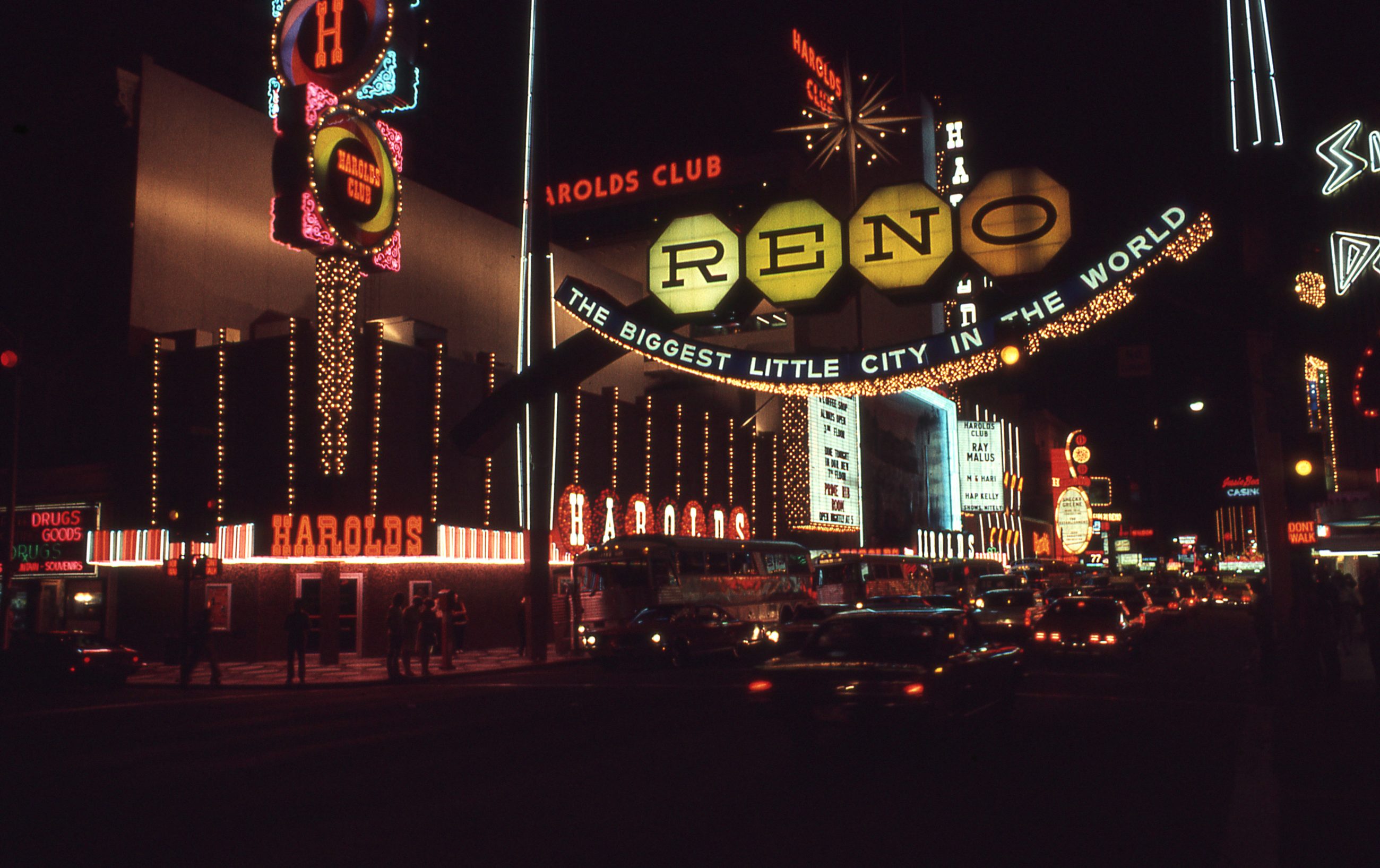 The illuminated Reno arch at night, its lights spelling "The Biggest Little City in the World" above Virginia Street.