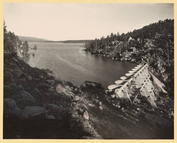 The 1912 Bear Valley Dam soon after completion, its row of concrete arches carrying a walkway, with Big Bear Lake behind.