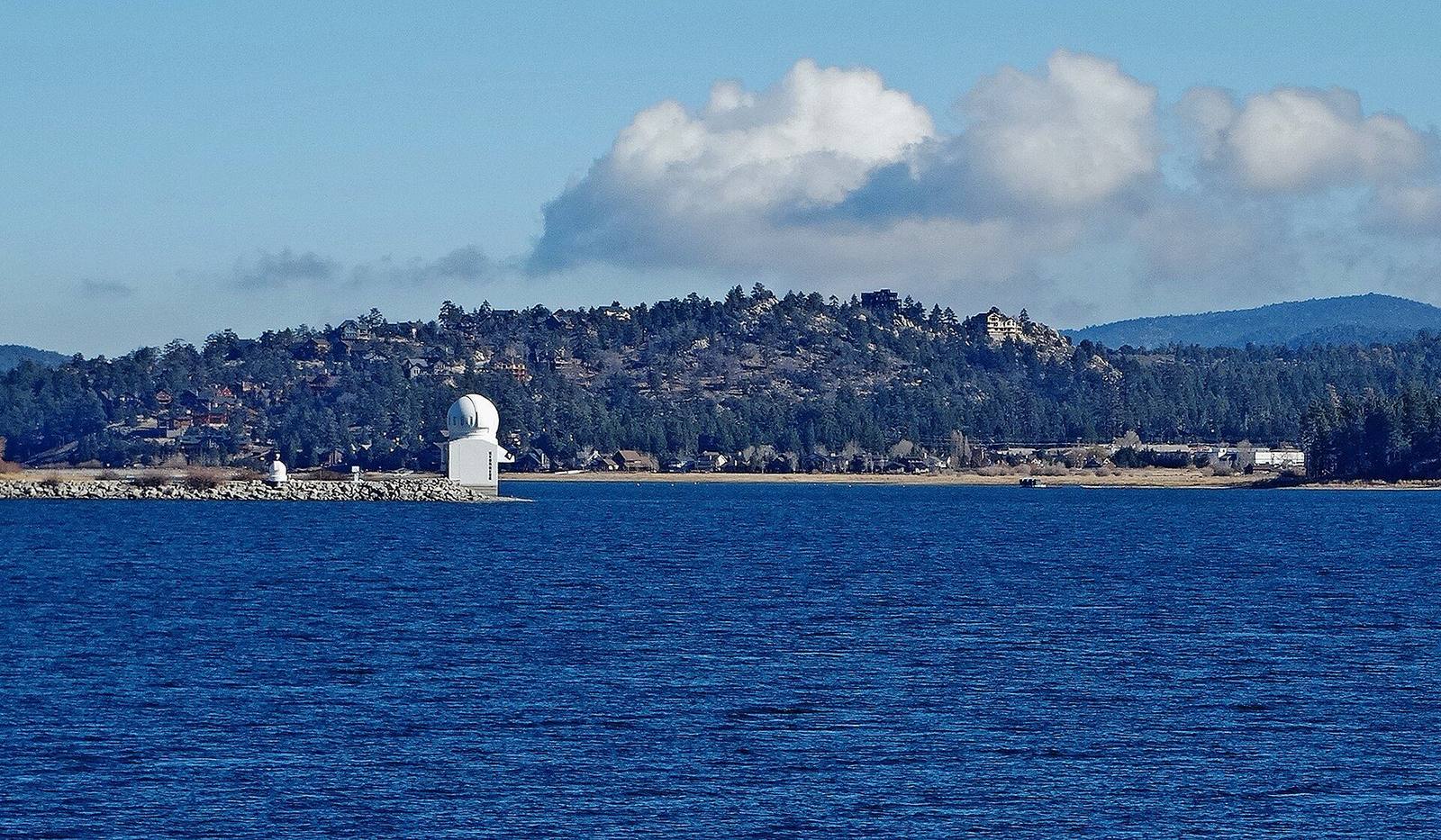 The white dome of the Big Bear Solar Observatory standing on its causeway out in the lake, the north shore behind it.