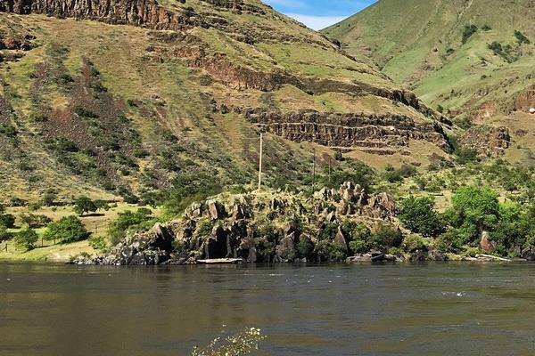 The Snake River at Buffalo Eddy, dark basalt outcrops along the far bank below grassy, rim-rocked canyon walls