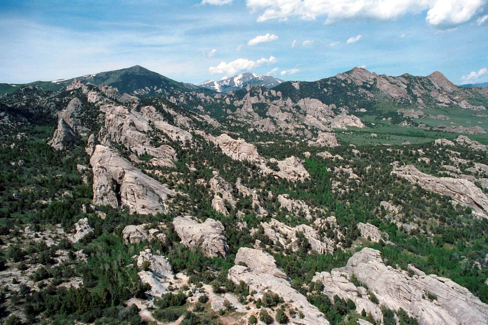 Granite spires and domes scattered through pine and juniper at City of Rocks, with Graham Peak and Cache Peak behind