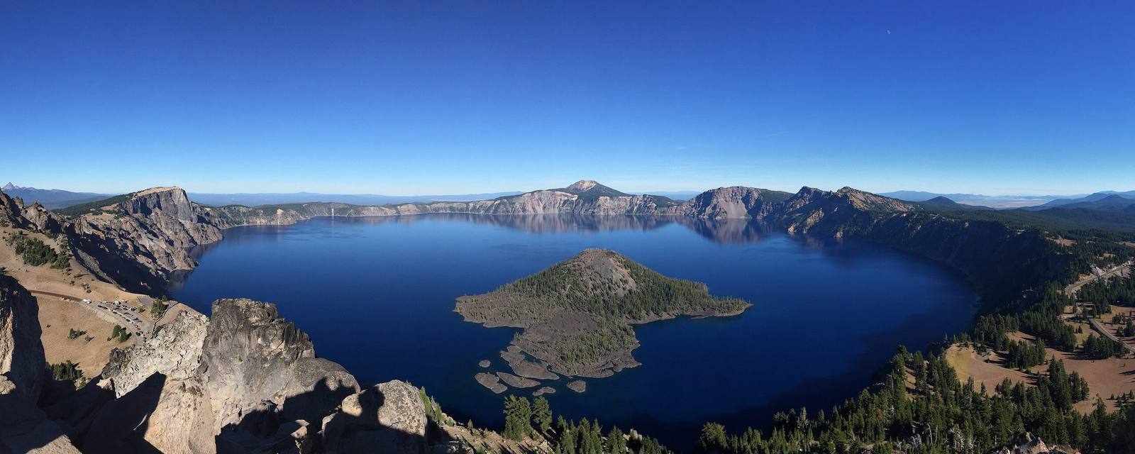 Crater Lake filling the collapsed caldera of Mount Mazama, Wizard Island rising from the blue water below the rim