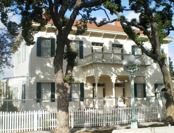 The surviving officers' quarters of Drum Barracks in Wilmington, a white two-storey building with green shutters behind a picket fence.