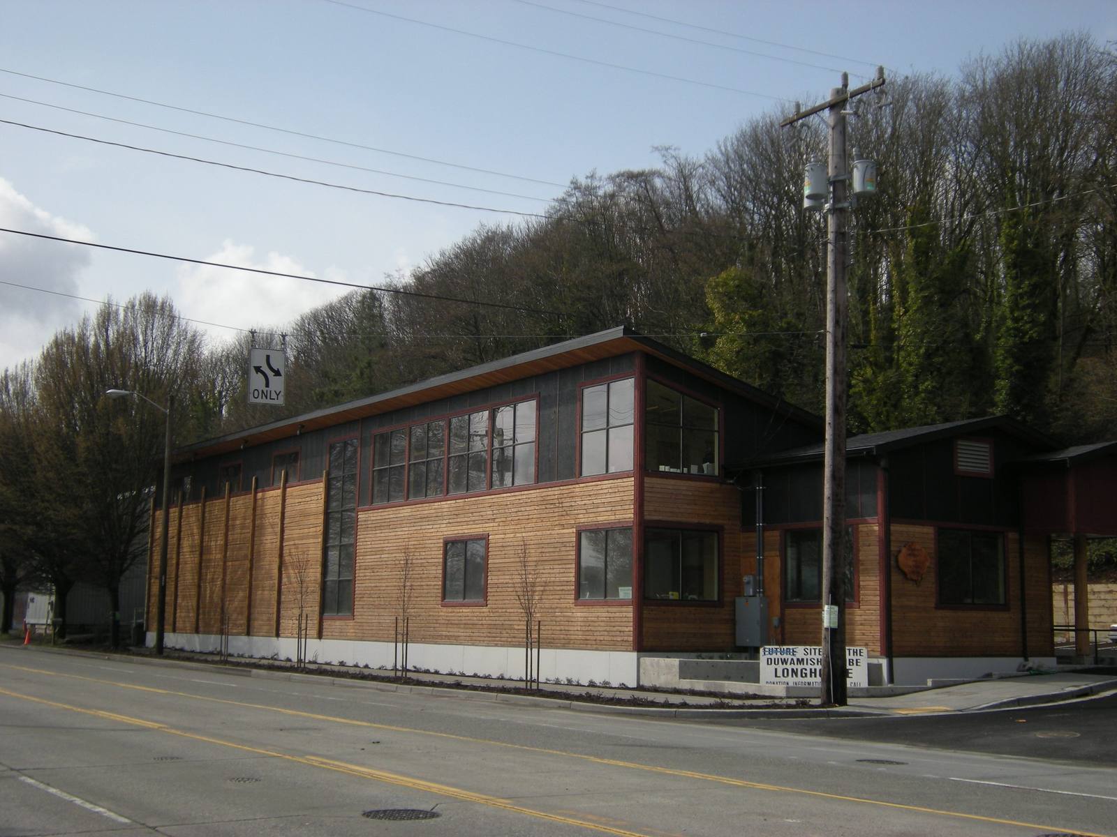 The cedar-clad Duwamish Longhouse and Cultural Center on West Marginal Way, wooded hillside behind