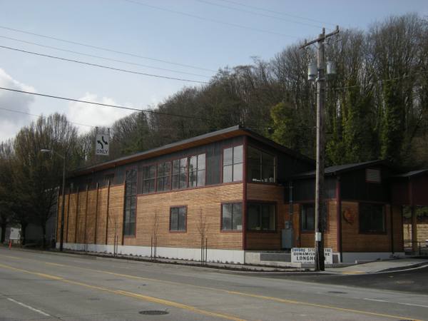 The cedar-clad Duwamish Longhouse and Cultural Center on West Marginal Way, wooded hillside behind