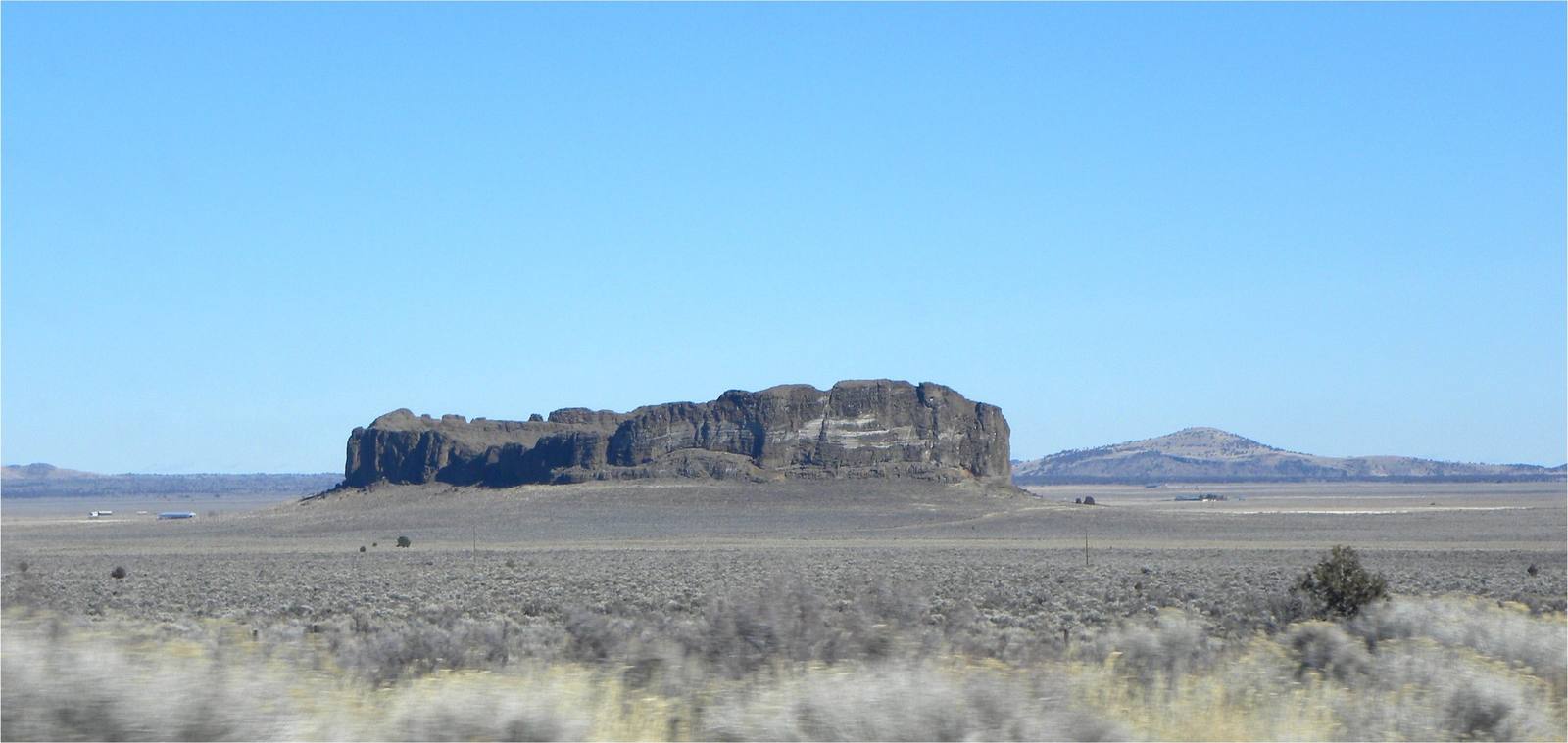 Fort Rock's broken tuff ring standing alone above the flat sage floor of the old lakebed