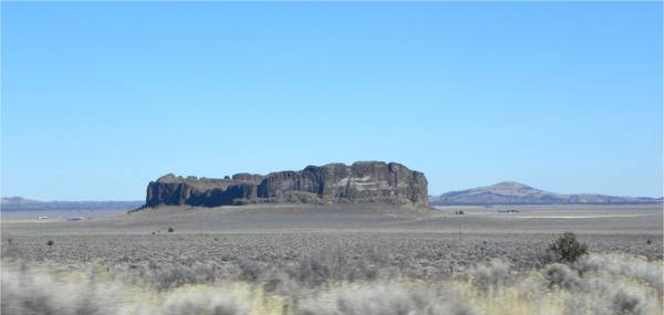 Fort Rock's broken tuff ring standing alone above the flat sage floor of the old lakebed
