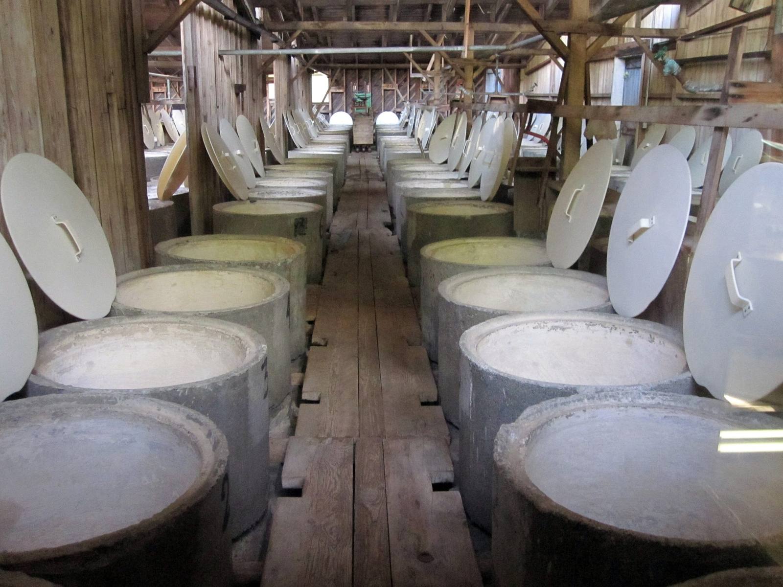 Two rows of lidded curing vats down the timber vat room at the Graber Olive House in Ontario.