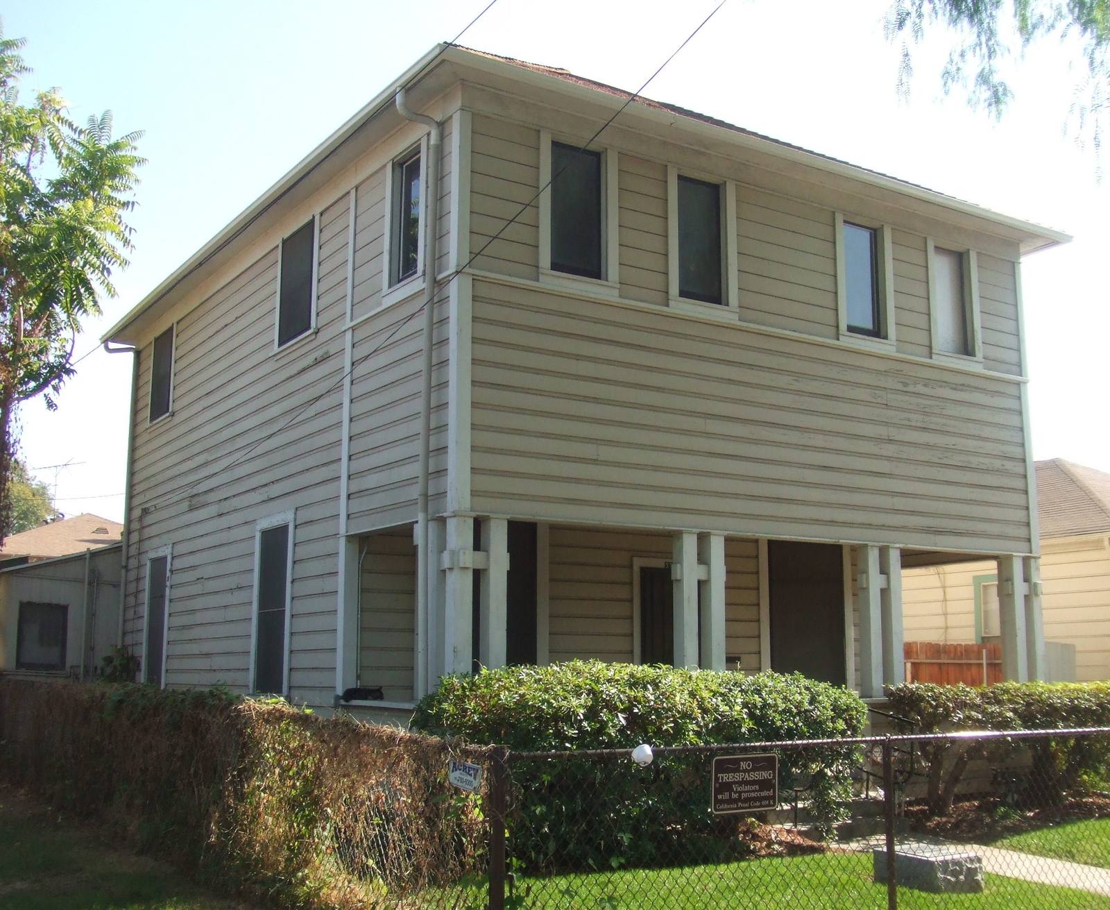 The two-storey clapboard Harada House on Lemon Street in Riverside, a hedge along the sidewalk.