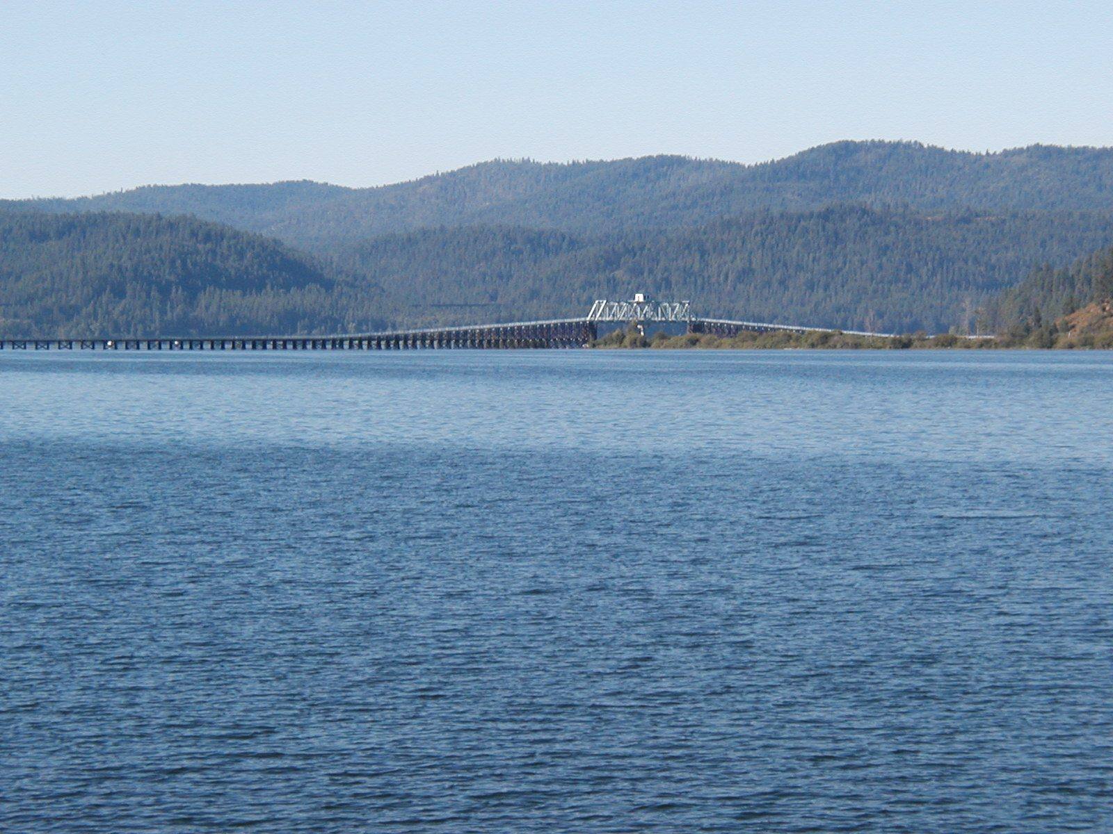 The long former railroad trestle crossing the southern end of Lake Coeur d'Alene below forested hills