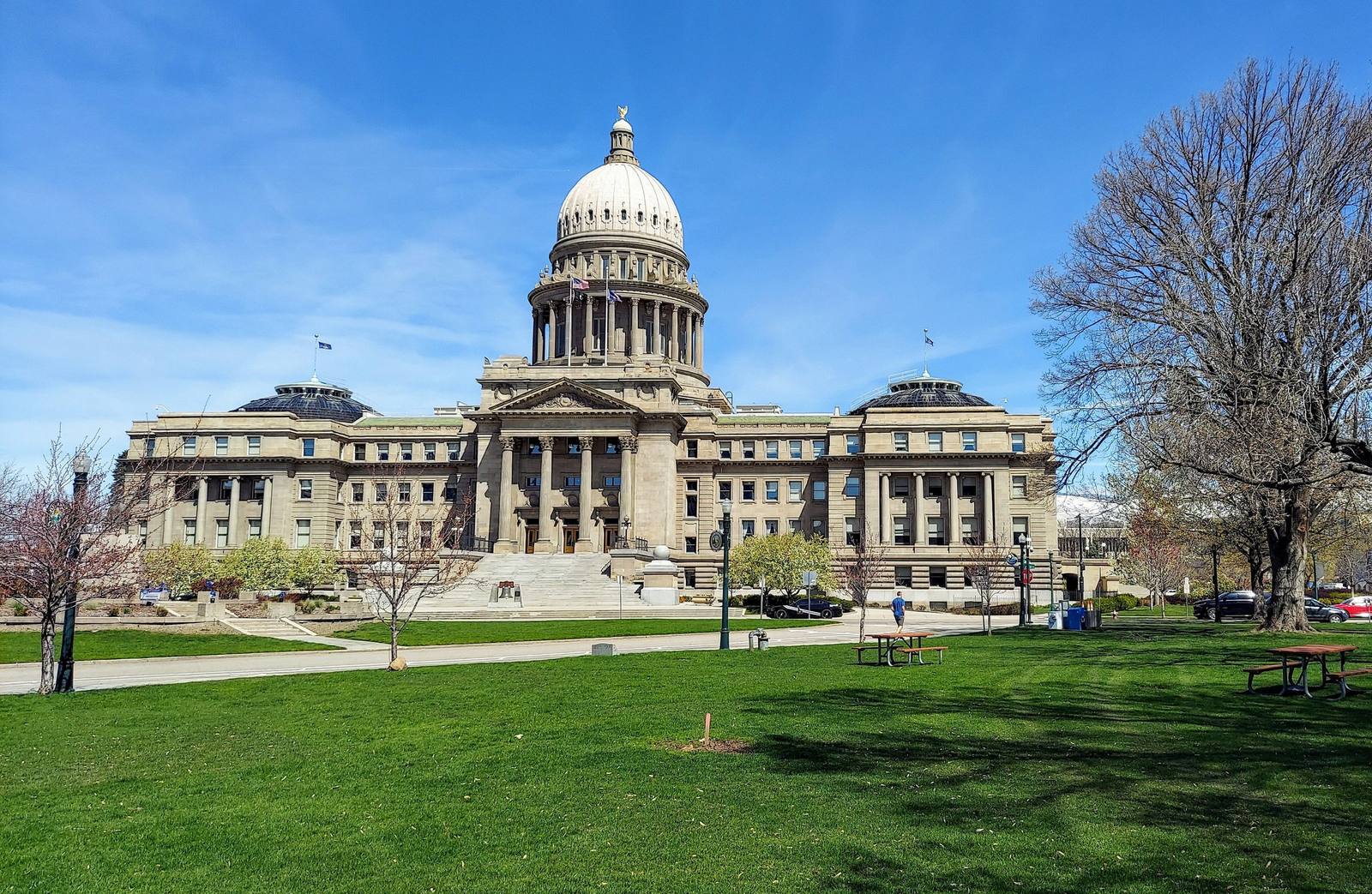 The domed sandstone Idaho State Capitol across its lawn in spring