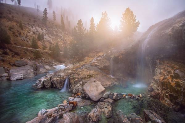 Hot water falling from a rock ledge into steaming pools beside the South Fork of the Payette at Kirkham