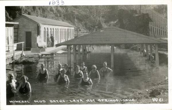 Bathers in the open mineral pool at Lava Hot Springs beside the bathhouse, in a 1939 real-photo postcard