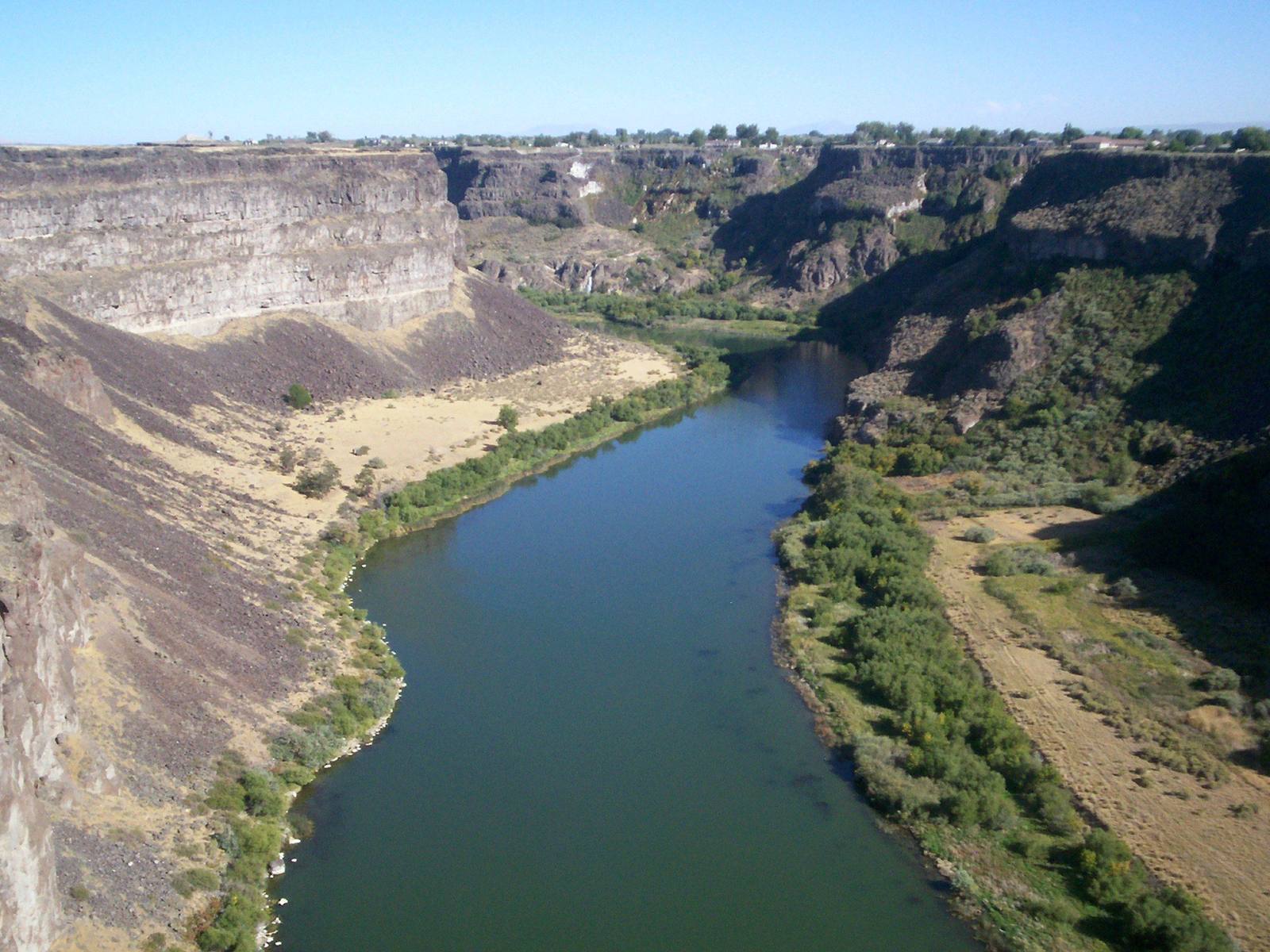 The Snake River winding through its basalt canyon near Twin Falls, with green farmland along the rim above