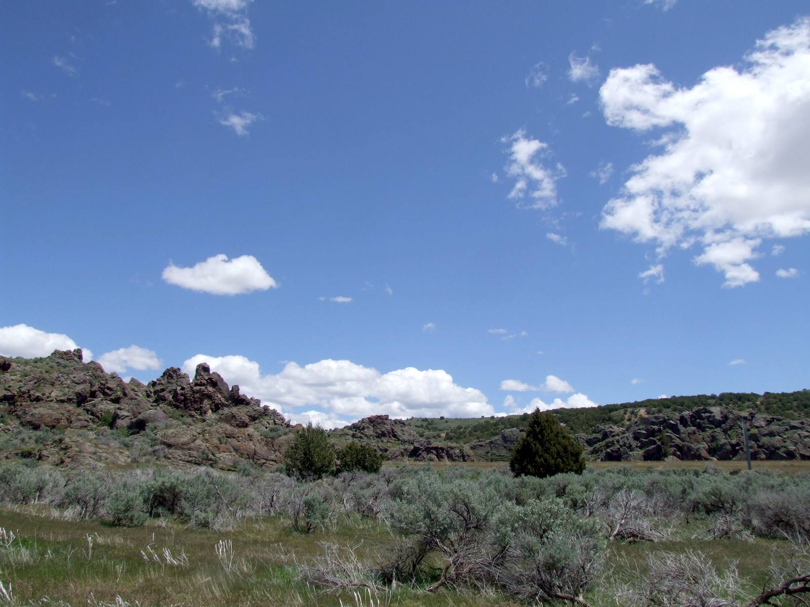 Dark volcanic outcrops above sagebrush at Massacre Rocks under a blue sky