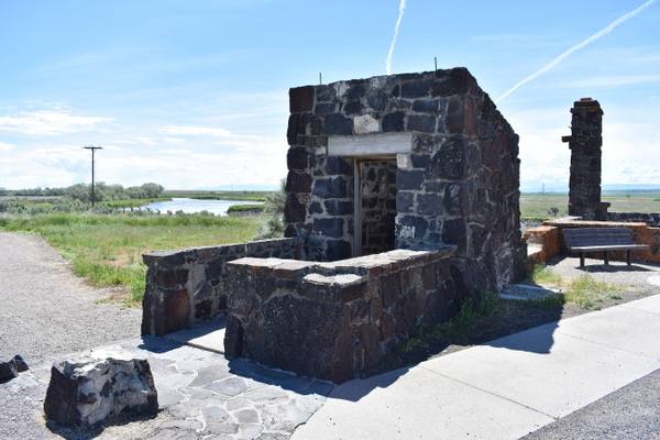 The ruined basalt walls of the guard station and waiting room at the entrance to the Minidoka camp