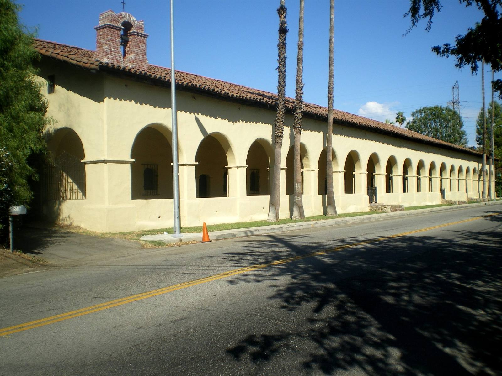 The convento at Mission San Fernando Rey de España, a long two-story adobe fronted by a colonnade of arches.