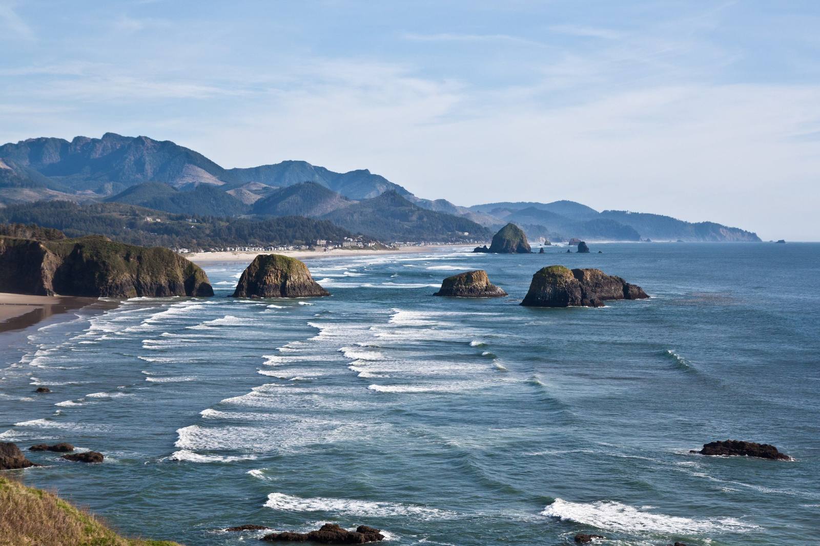 Surf breaking around sea stacks on the north Oregon coast near Cannon Beach, the Coast Range behind