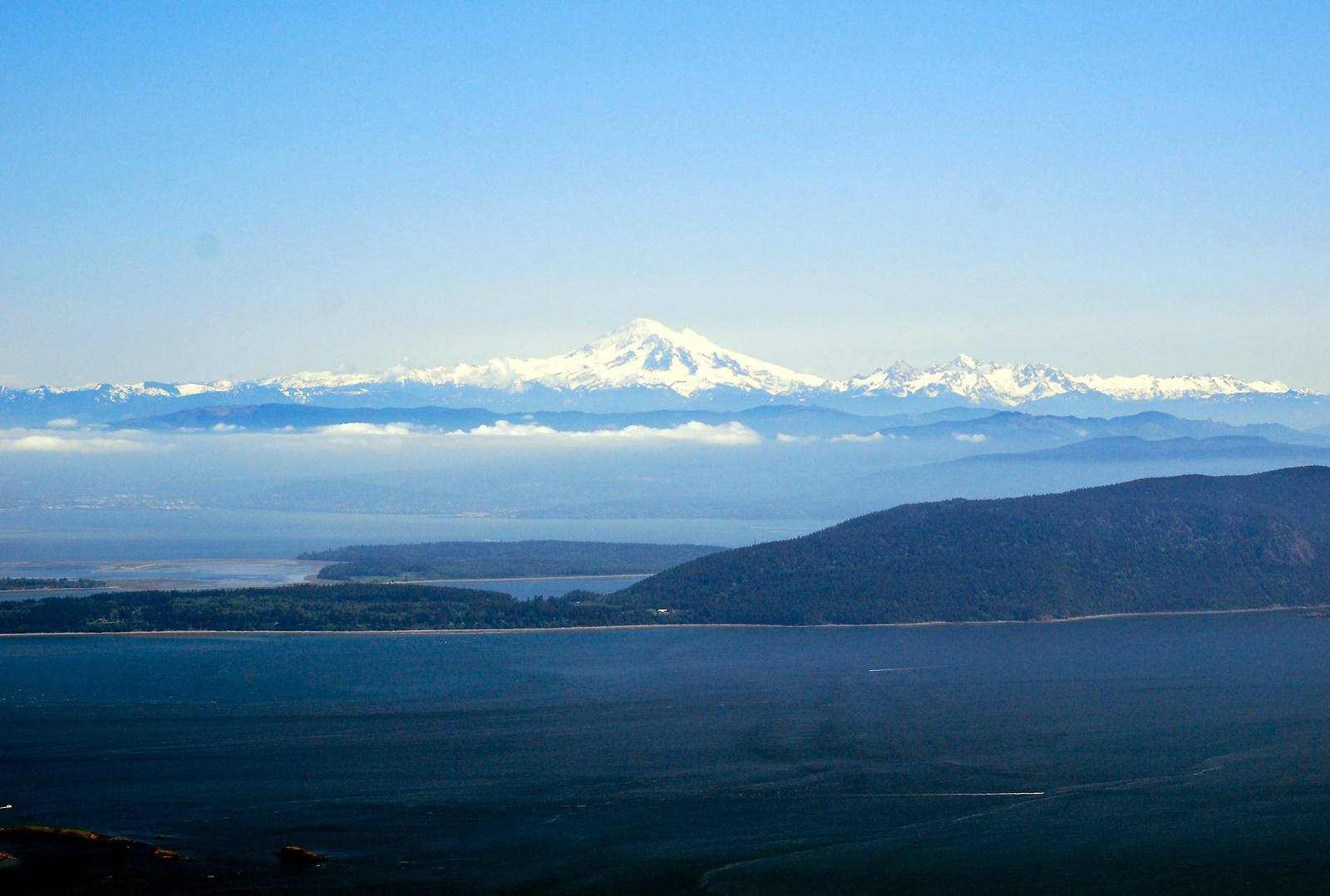 Mount Baker rising white above the haze beyond the islands and channels of the San Juans, seen from the top of Mount Constitution on Orcas Island