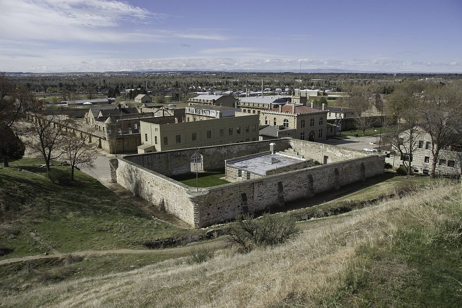The sandstone walls and cell houses of the Old Idaho Penitentiary seen from the foothill slope above