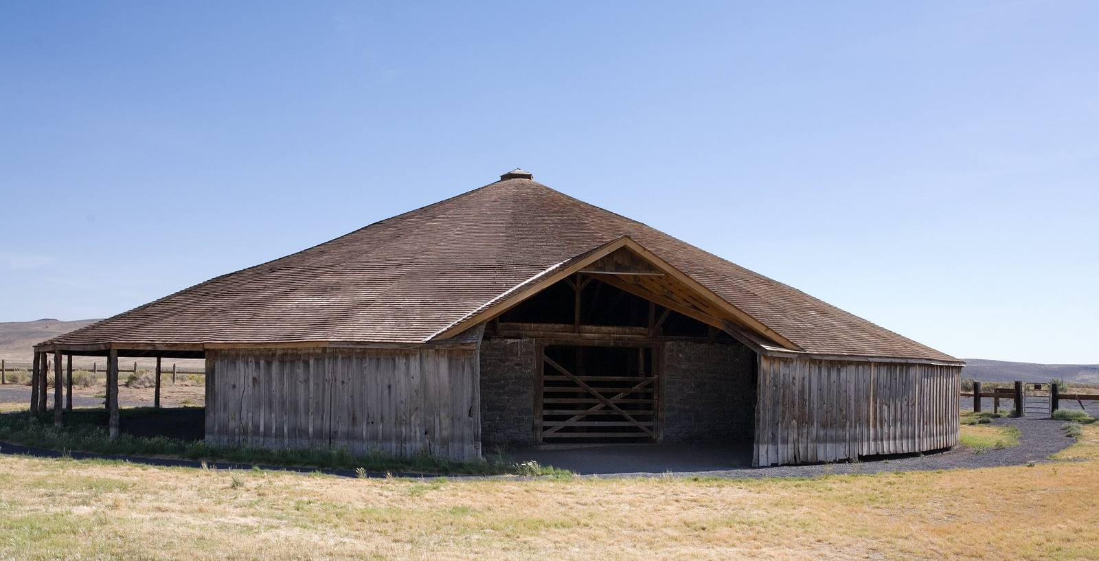 Pete French's round barn, a low conical roof over plank and stone walls on the open sage plain