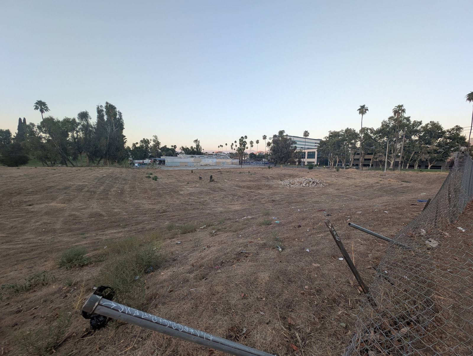 The empty fenced lot in the Tequesquite Arroyo where Riverside's second Chinatown stood, a fallen fence post in the foreground.