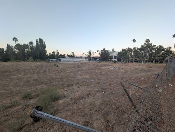 The empty fenced lot in the Tequesquite Arroyo where Riverside's second Chinatown stood, a fallen fence post in the foreground.
