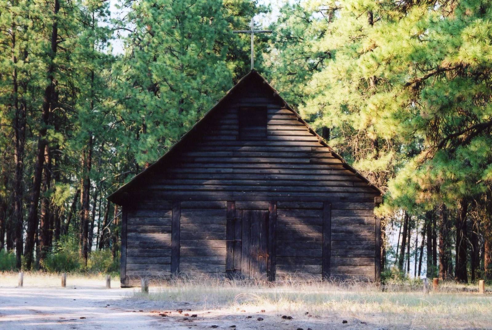 The small hewn-log chapel of St. Paul's Mission among ponderosa pines