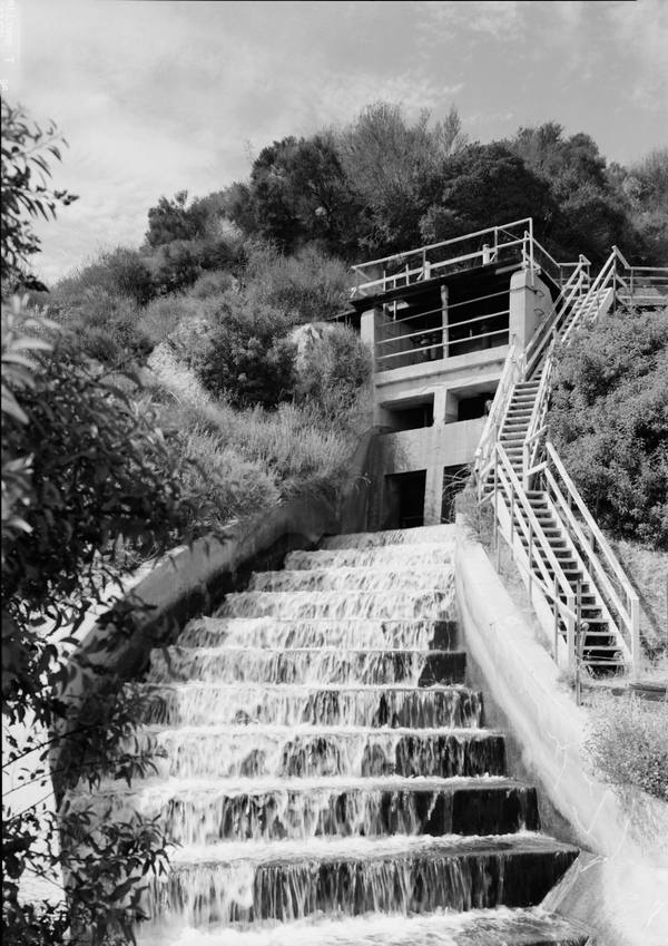 Water running down the stepped concrete chute of the first Los Angeles Aqueduct cascade at Sylmar, below the portal structure.