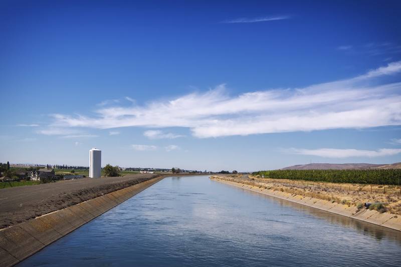 The concrete-lined West Canal of the Columbia Basin Project running straight across flat farmland near Lakeview, under a wide blue sky