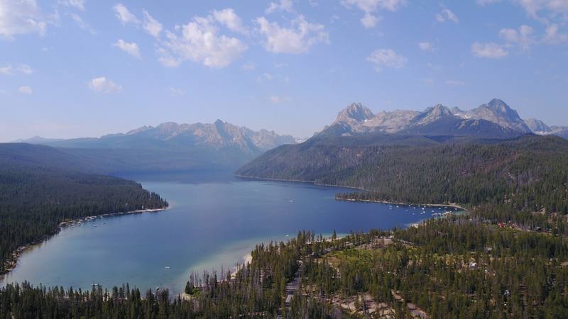 Redfish Lake stretching into the Sawtooth Range from above, forest along its shores