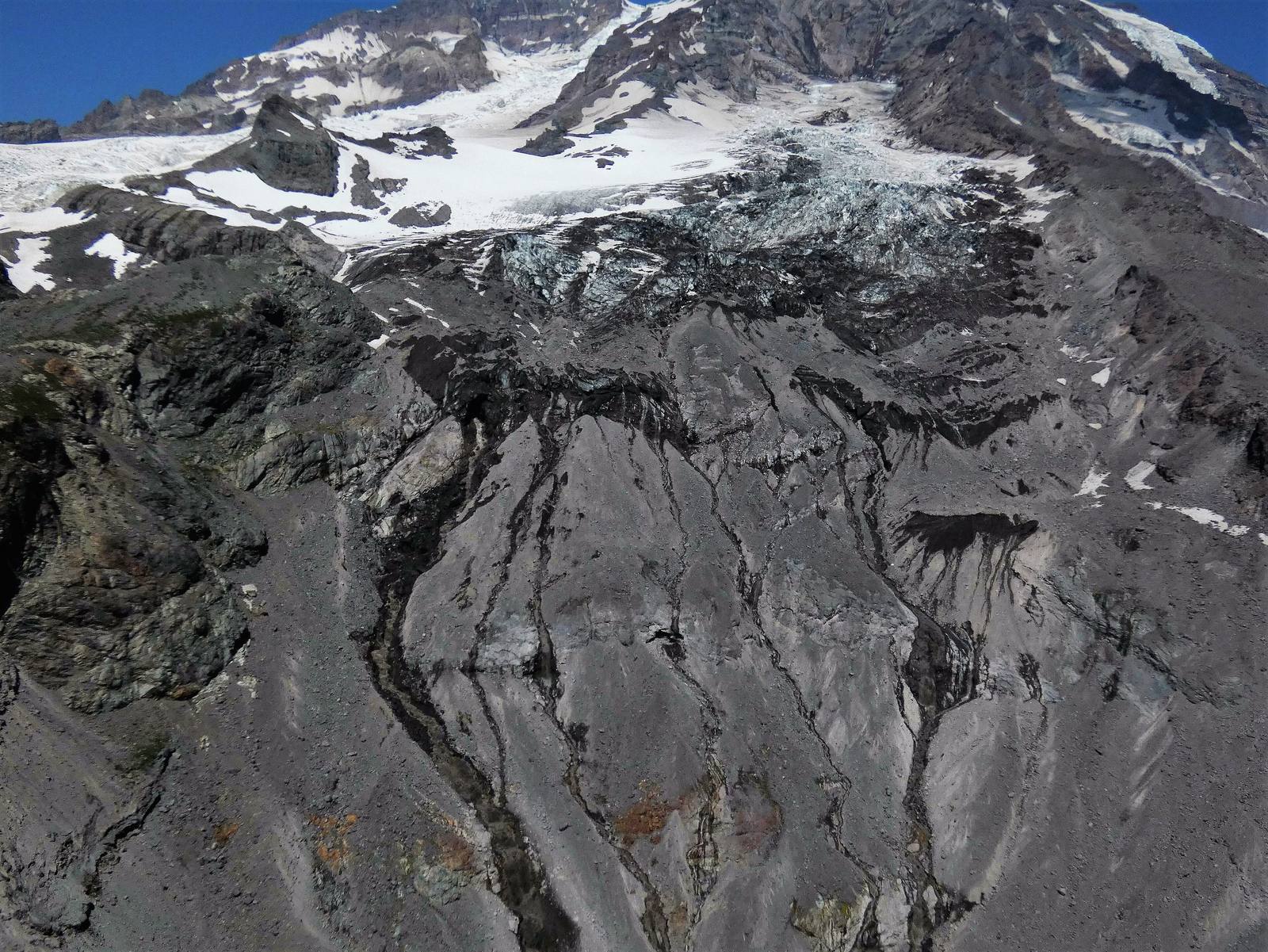 The South Tahoma Glacier on Mount Rainier's southwest flank, broken ice above a slope of dark rock and debris channels
