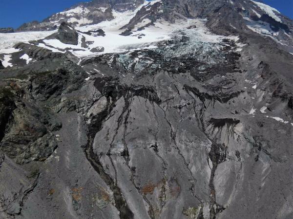 The South Tahoma Glacier on Mount Rainier's southwest flank, broken ice above a slope of dark rock and debris channels