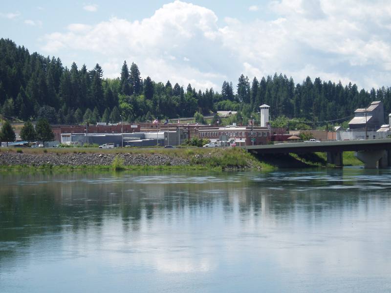 The town of Bonners Ferry and its highway bridge on the Kootenai River, forested hills behind