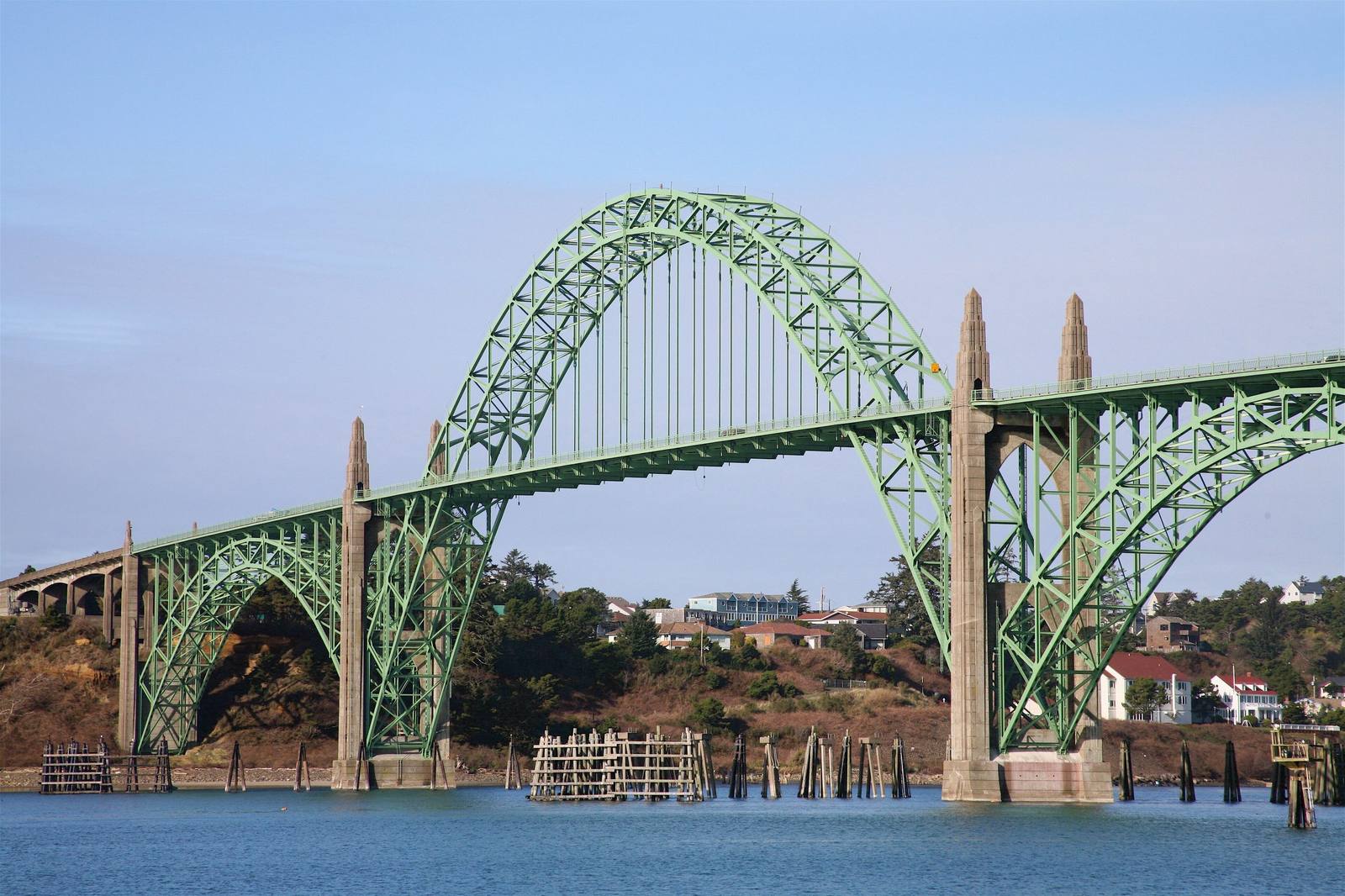 The green steel arch of the Yaquina Bay Bridge carrying US-101 over the bay at Newport