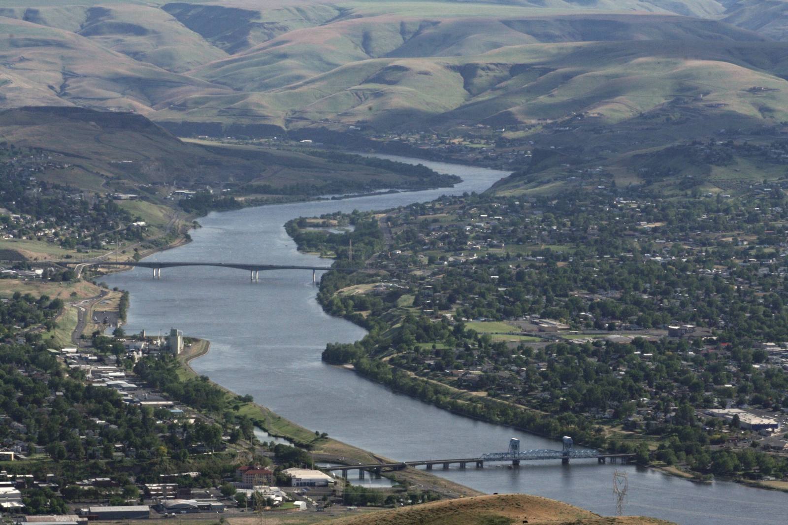 The Snake River running south between Lewiston, Idaho, on the left and Clarkston, Washington, on the right, the lift towers of the 1939 Interstate Bridge in the foreground and the Southway Bridge beyond.