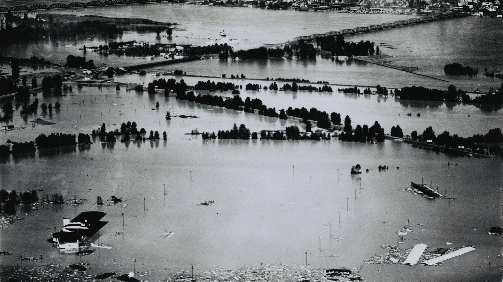 Aerial photograph of Vanport under floodwater in 1948, rooftops and wreckage scattered across the drowned grid