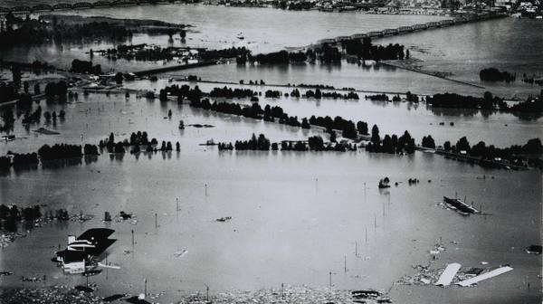 Aerial photograph of Vanport under floodwater in 1948, rooftops and wreckage scattered across the drowned grid