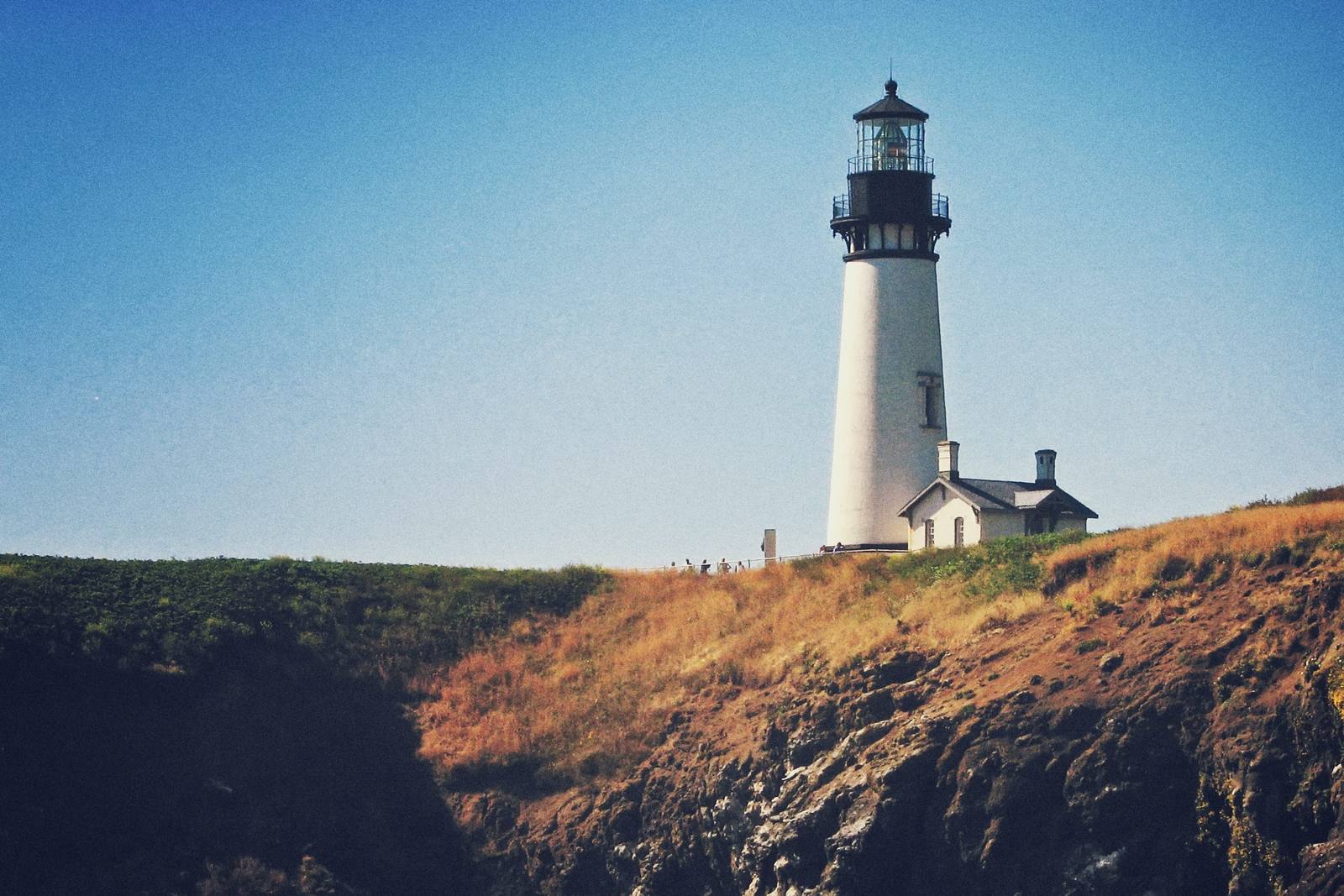 Yaquina Head Lighthouse and its keeper's building on the headland above Cobble Beach