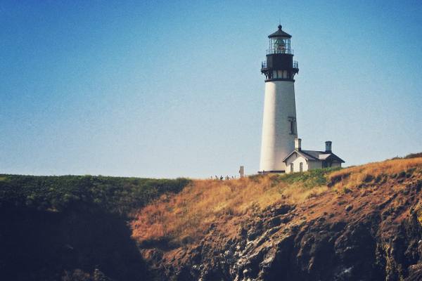 Yaquina Head Lighthouse and its keeper's building on the headland above Cobble Beach